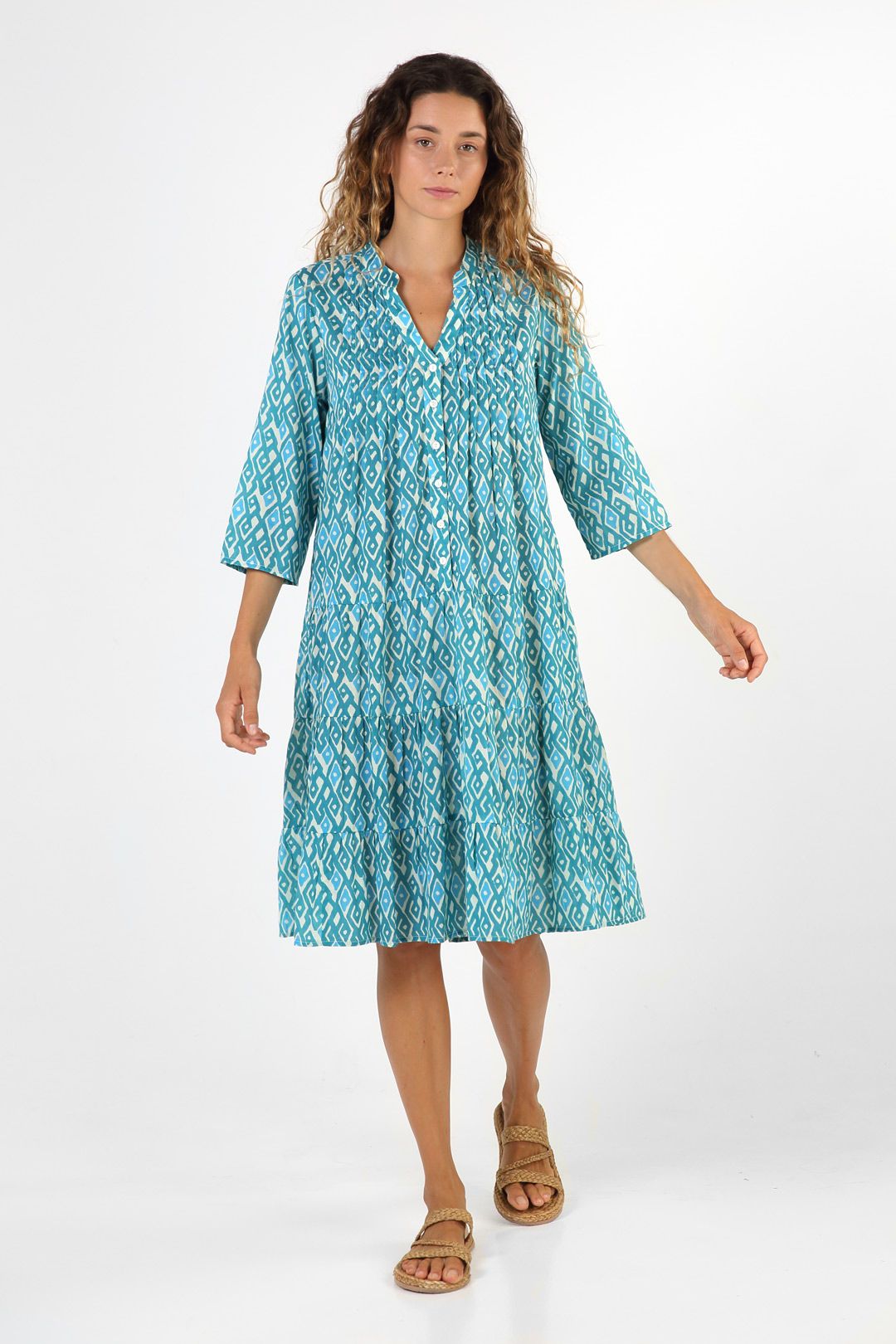 Vestido turquesa con estampado geométrico de inspiración bohemia, look Mandum 2025 con estilo mediterráneo y sostenible.